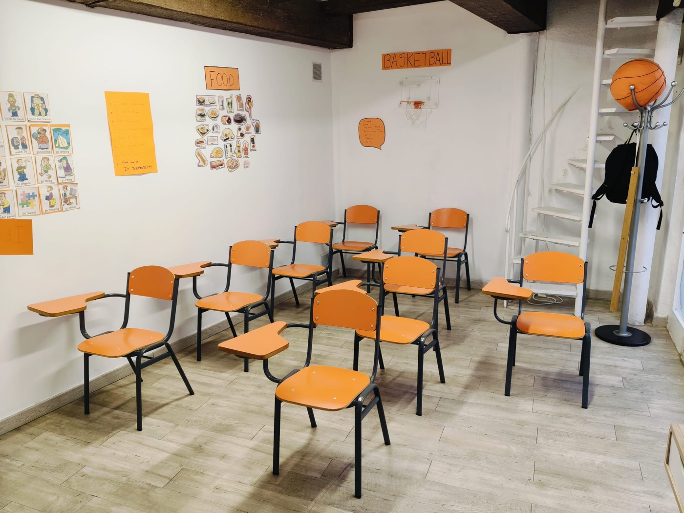Aula de CoolCats English con sillas naranjas y pósters didácticos